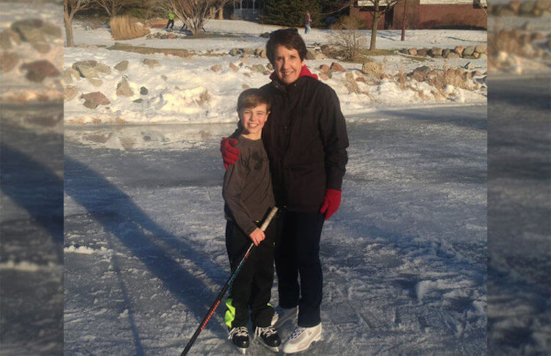 Grandmother playing ice hockey with grandson