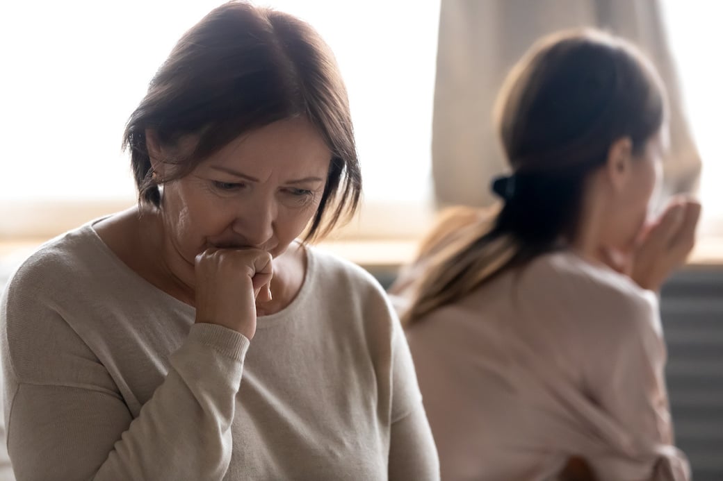 Senior mother looking sad next to adult daughter