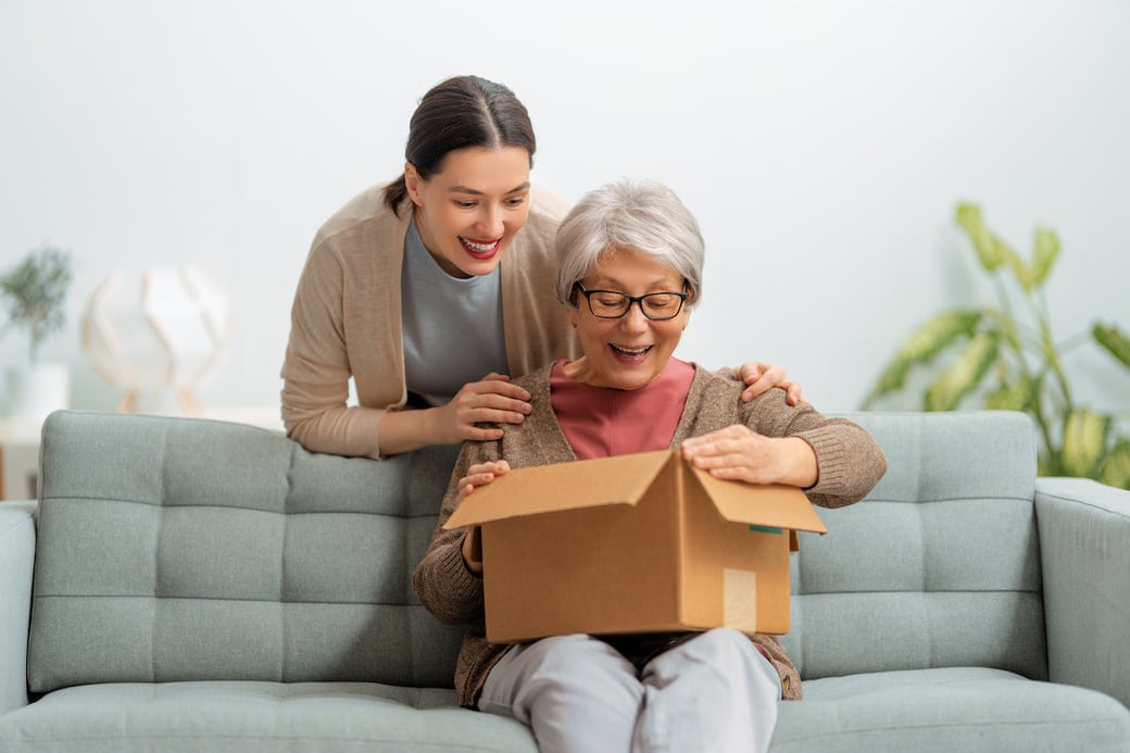 Woman gifting senior woman a care package