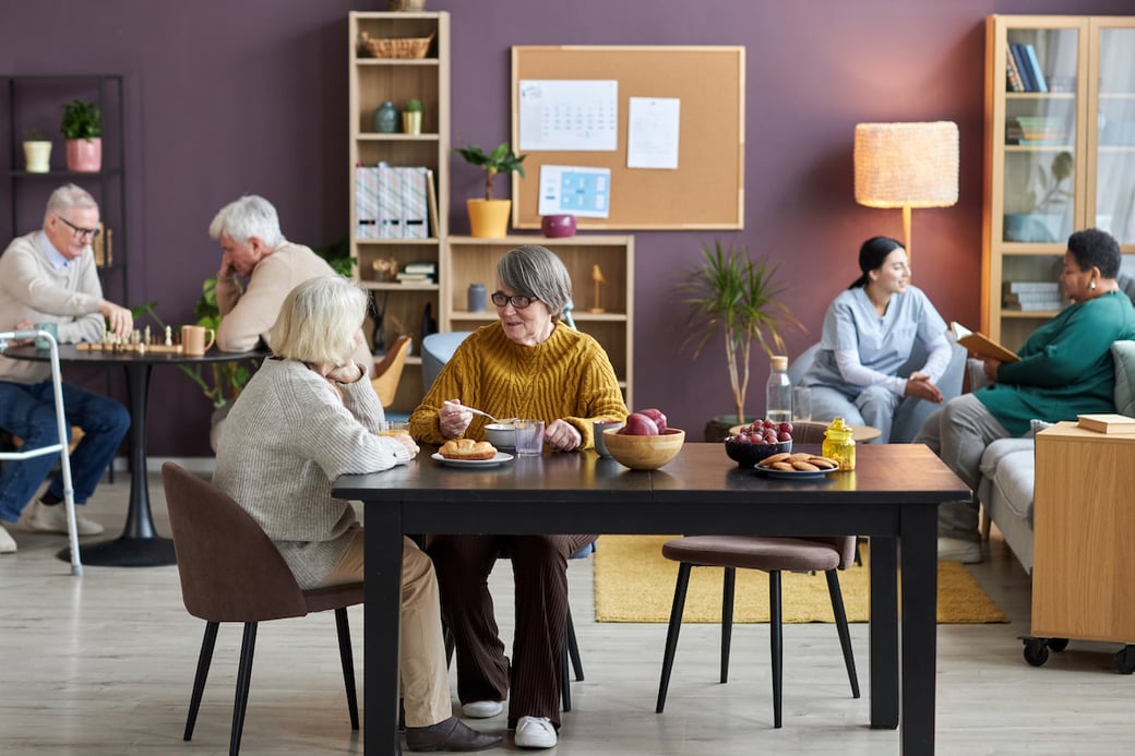 Seniors enjoying indoor activities with friends and caregiver