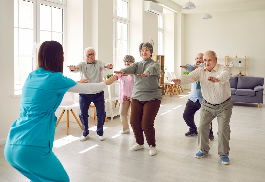 Seniors doing knee bends in an exercise class