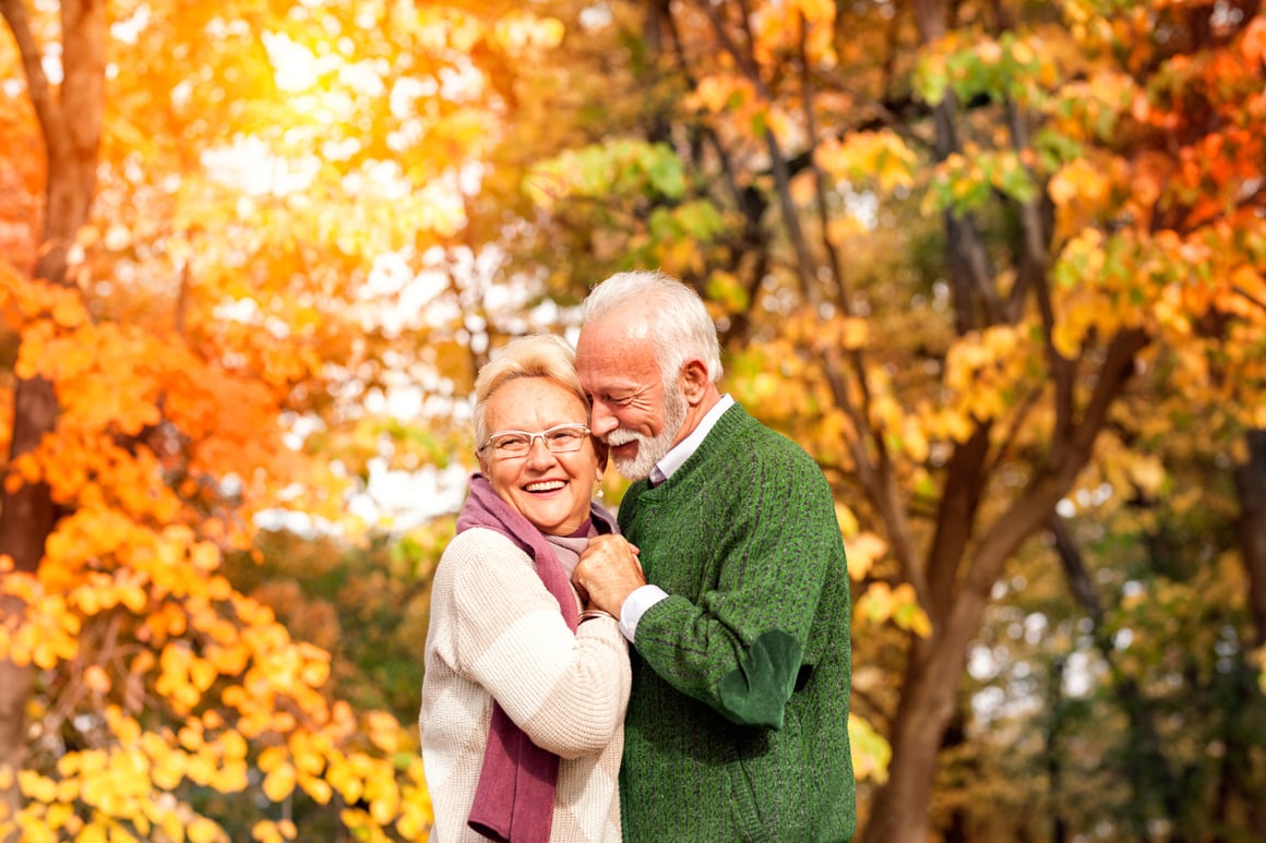 Couple embracing among fall trees