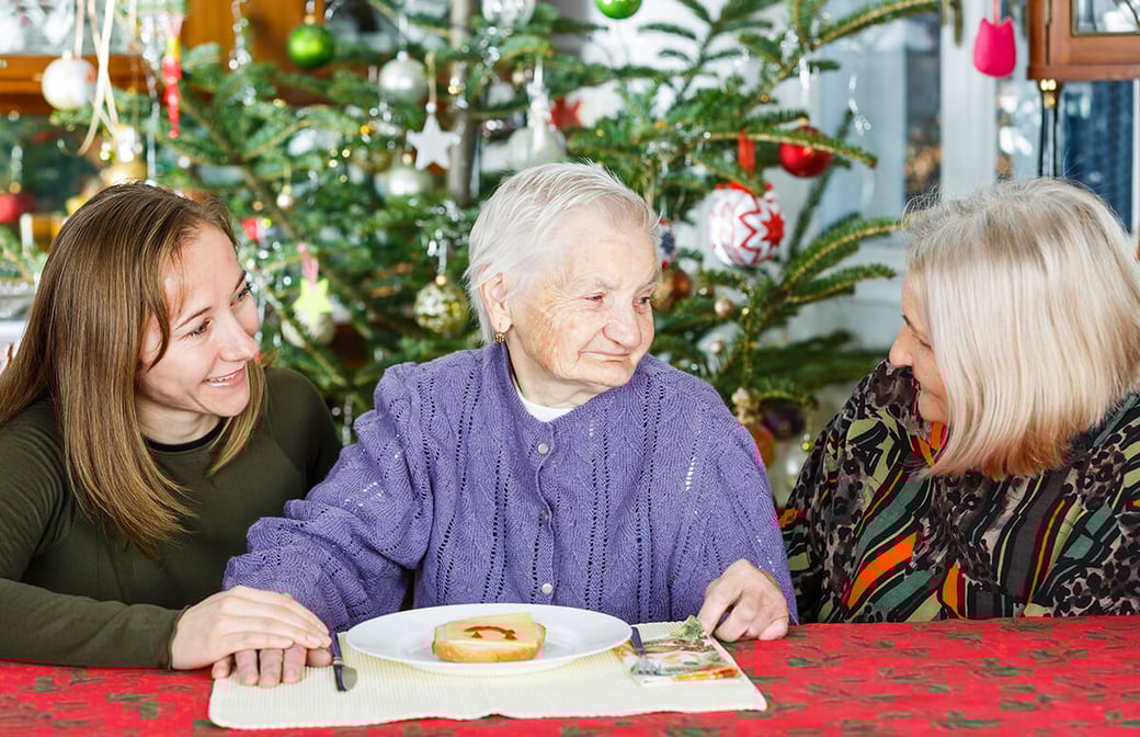 Mother and daughter visiting senior grandmother for the holidays
