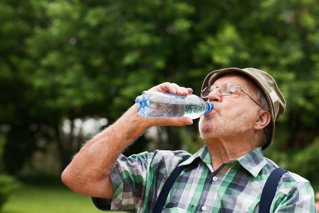 Senior man drinking out of water bottle