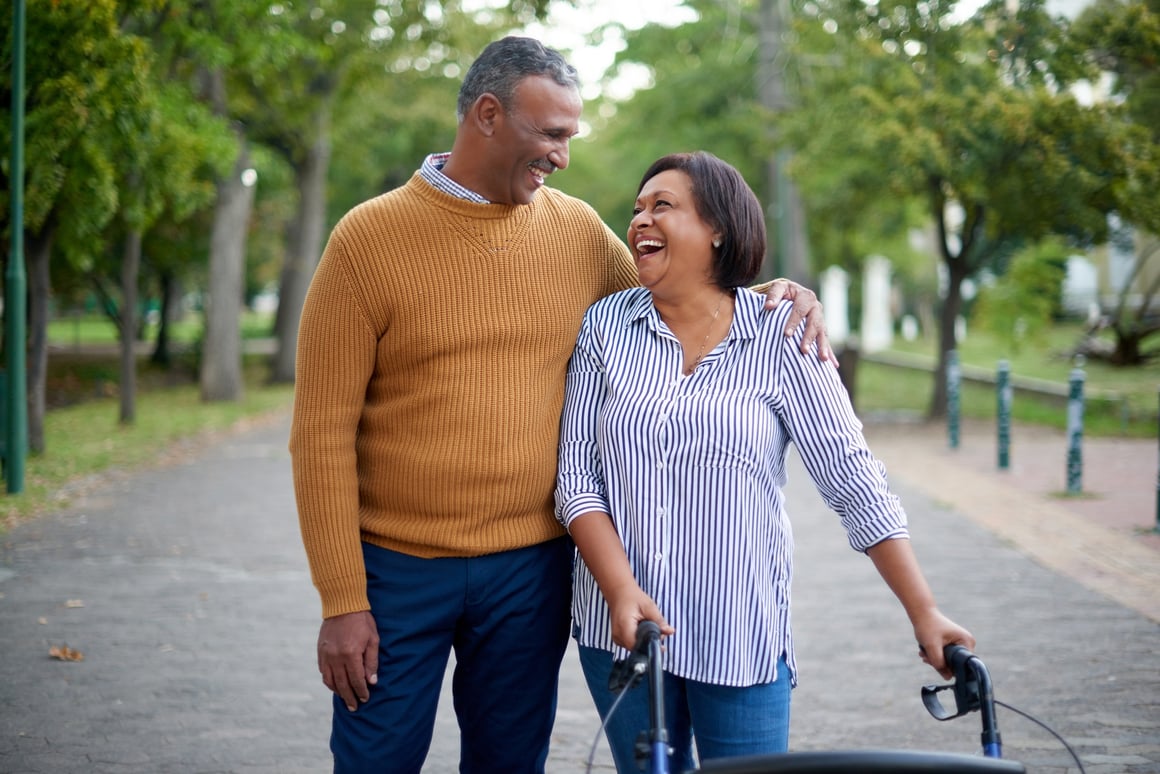 Senior man and woman with walker taking a walk outside