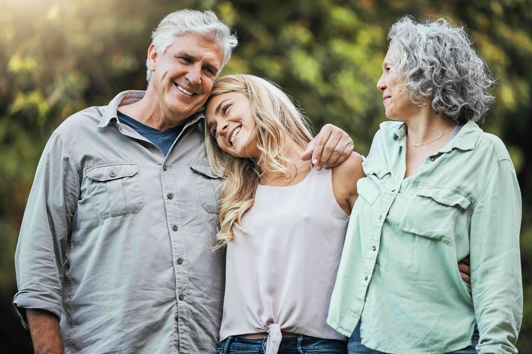 Young woman hugging senior couple