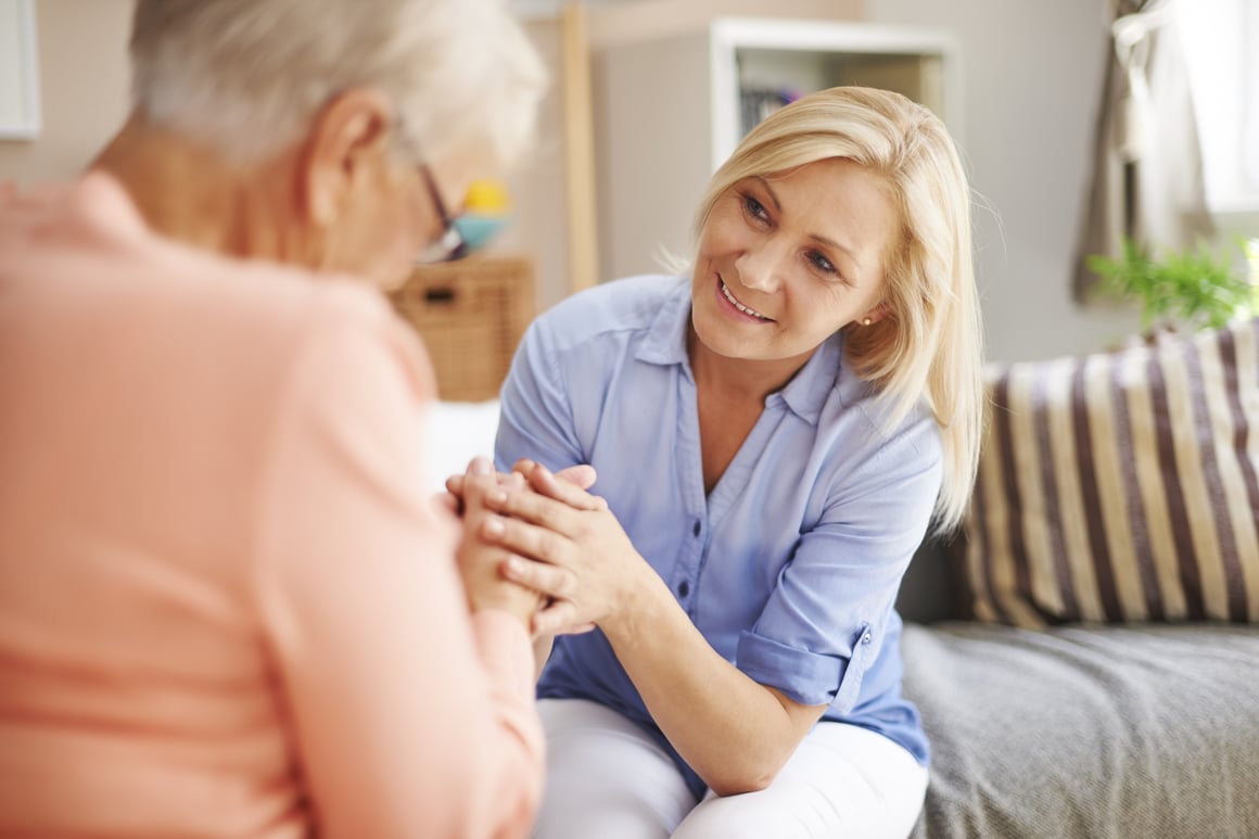 Caregiver holding senior woman's hands