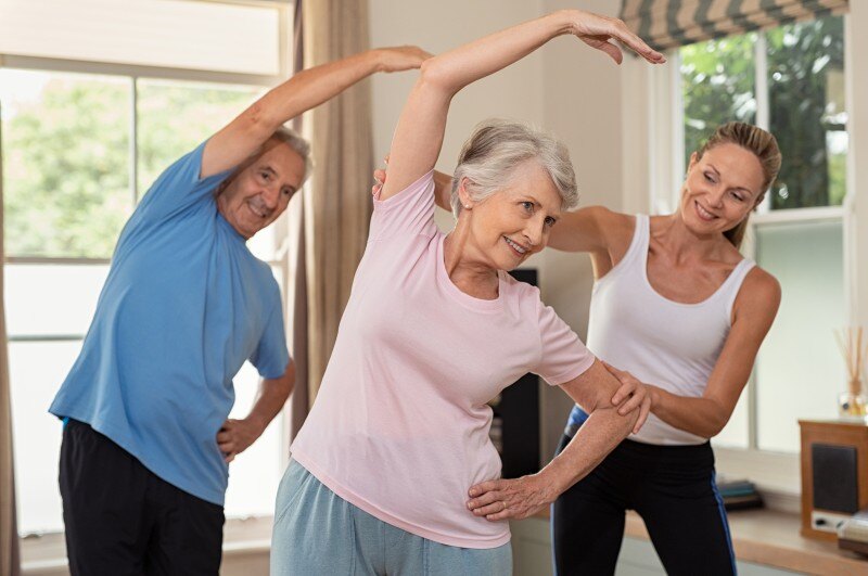 Seniors attending an exercise class with the help of an instructor