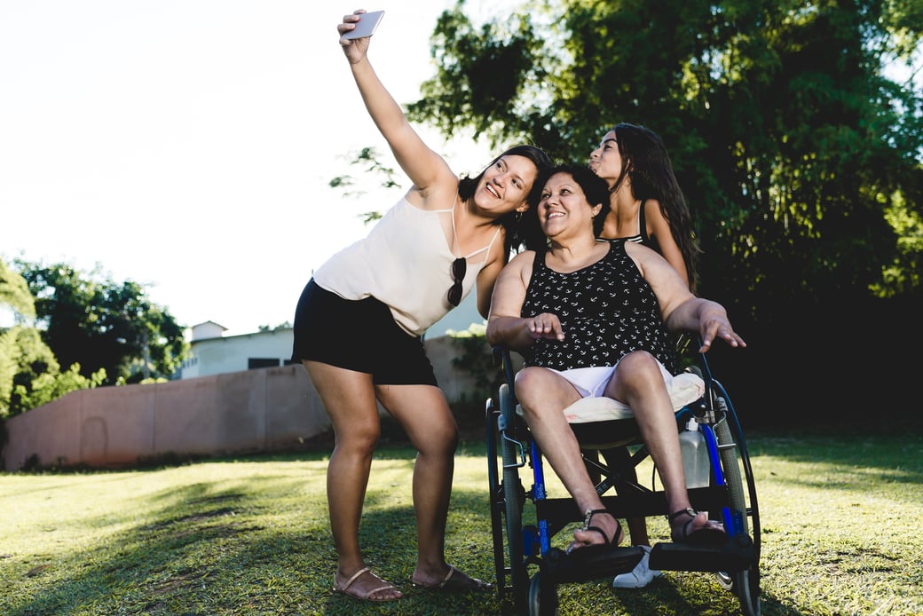 Family members take photo with senior in wheelchair