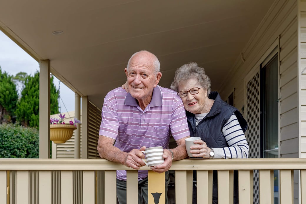 Senior couple enjoying coffee on their front porch