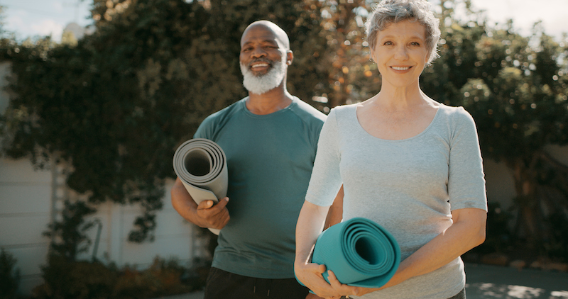 Active seniors with yoga mats