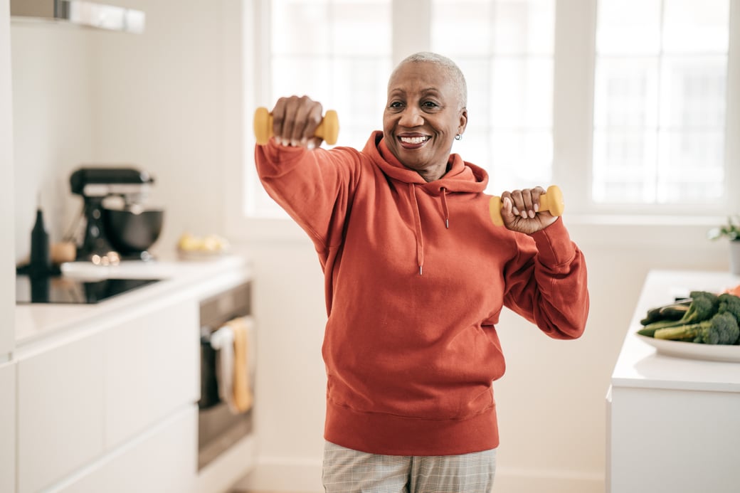 Senior woman lifting weights indoors