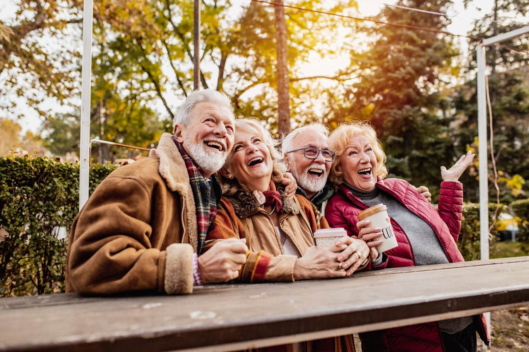 Group of seniors enjoying coffee outdoors in autumn