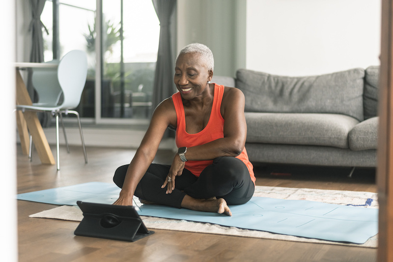 Senior woman doing virtual yoga class