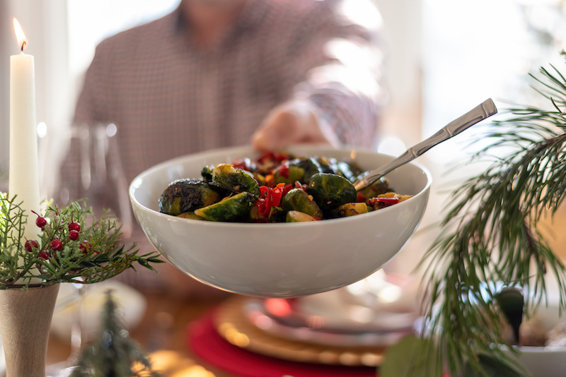 Senior holding holiday meal side dish