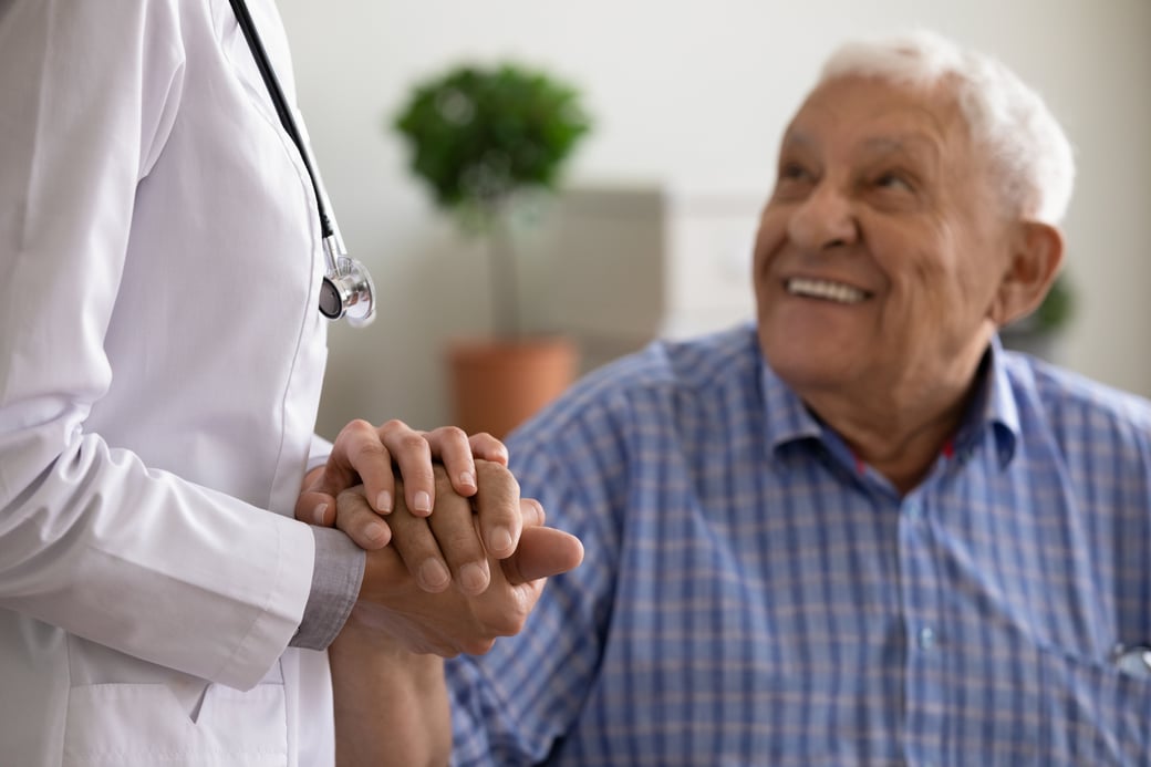 Senior man holding hand of doctor