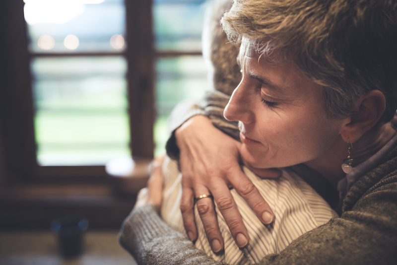Adult woman hugging senior woman