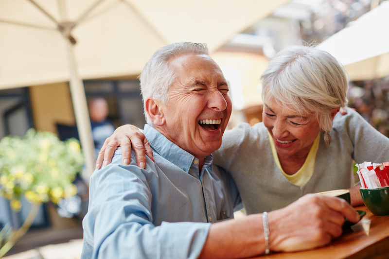 Senior couple laughing while drinking coffee