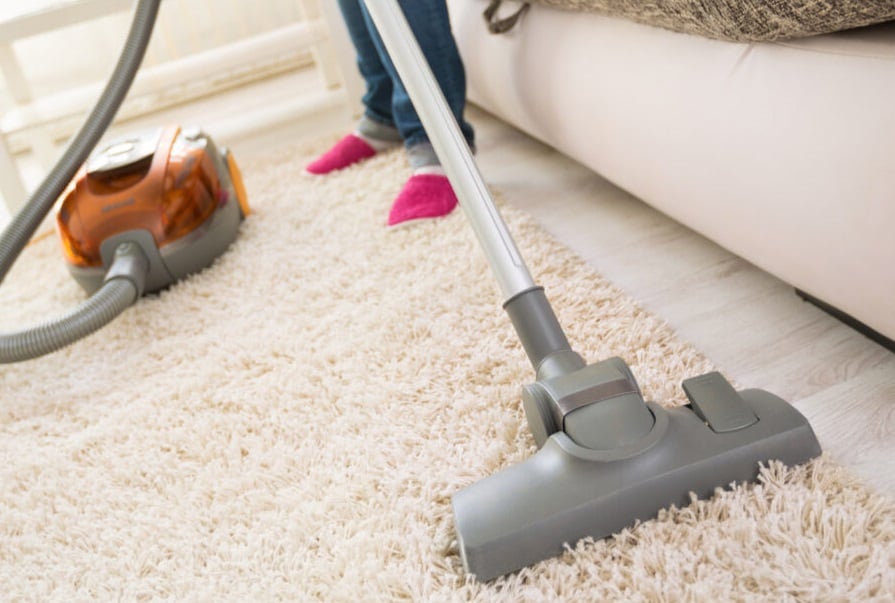 Woman vacuuming rug