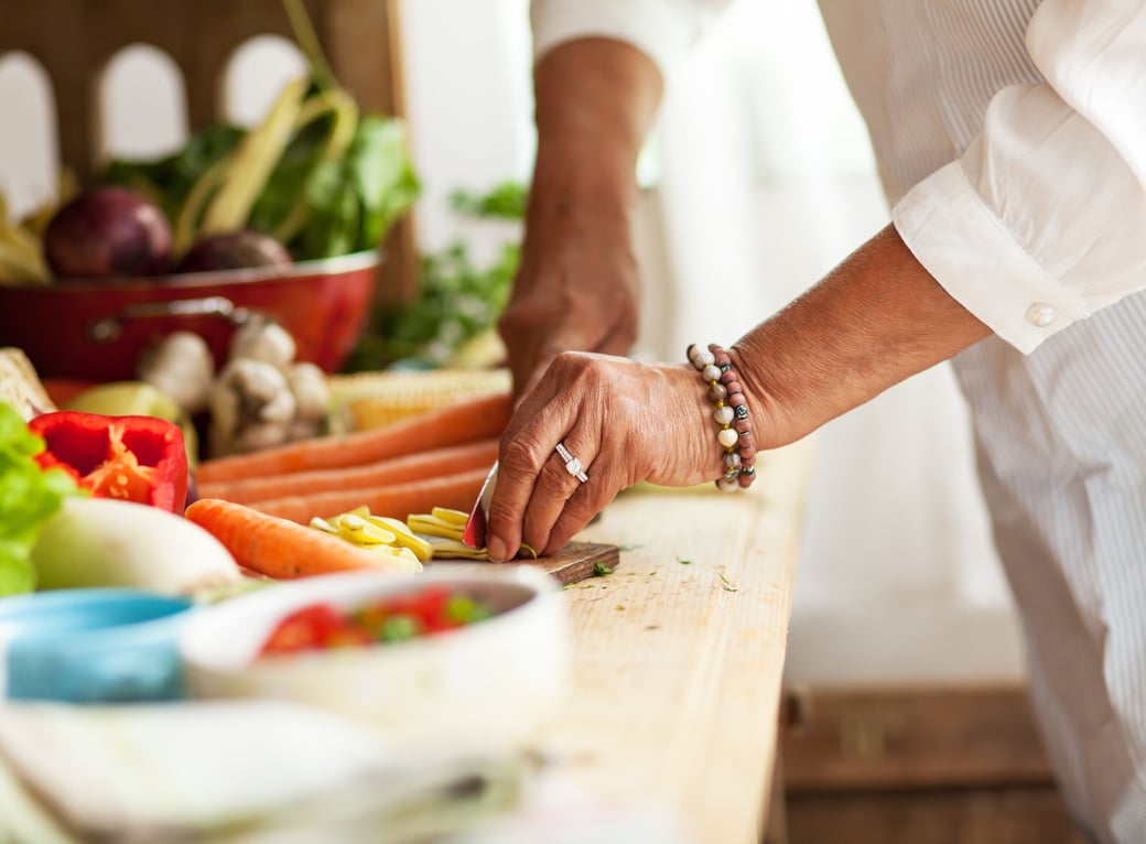 Senior woman chopping vegetables on a counter