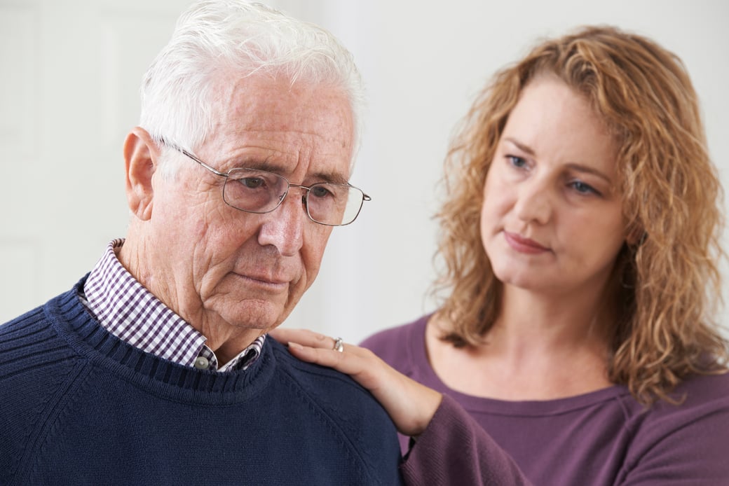 Adult daughter comforting grieving father