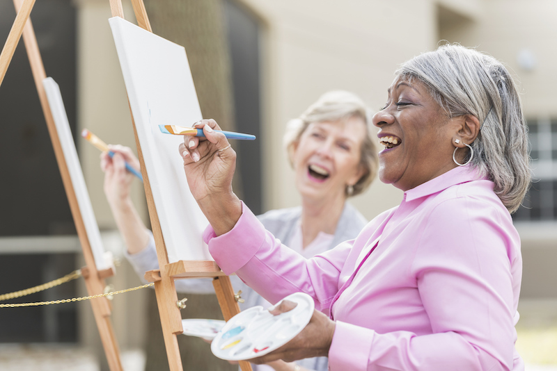 Senior women painting on canvases