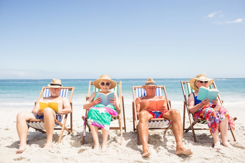 Group of seniors reading on the beach