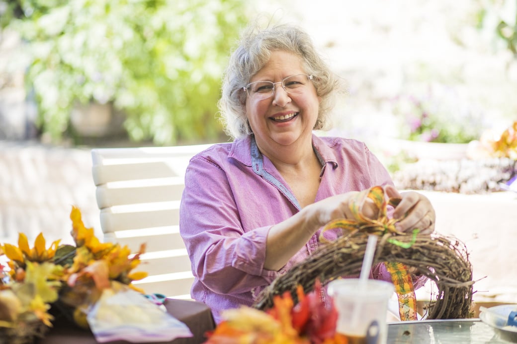 Senior woman making a fall wreath