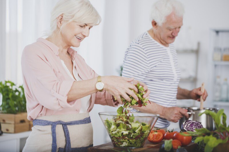 Senior couple making a fresh salad