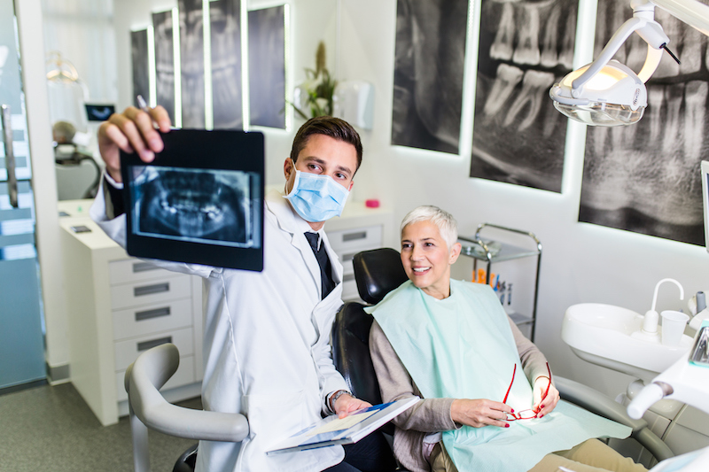 Senior woman looking at x-rays with dentist