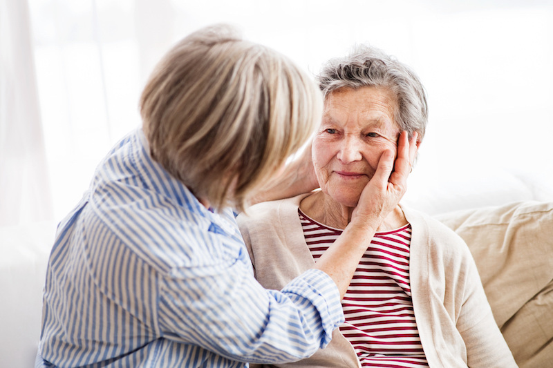 Woman holding senior woman's face