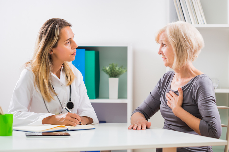 Senior woman talking to doctor about heart problems